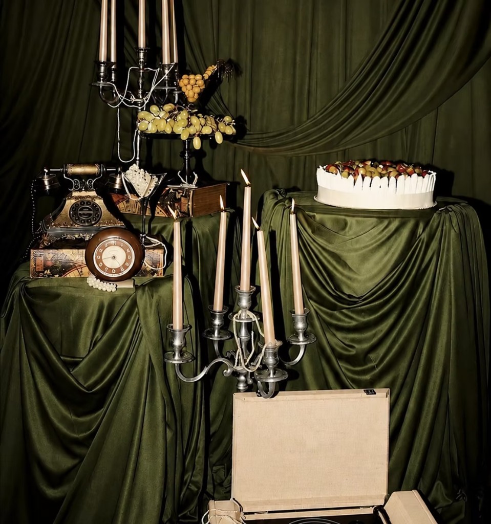 A celebration table with candles, fruit, and a cake