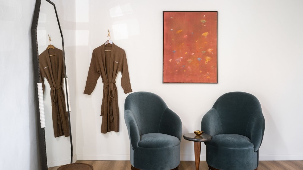 Studio seating area with robes, a mirror, and two chairs